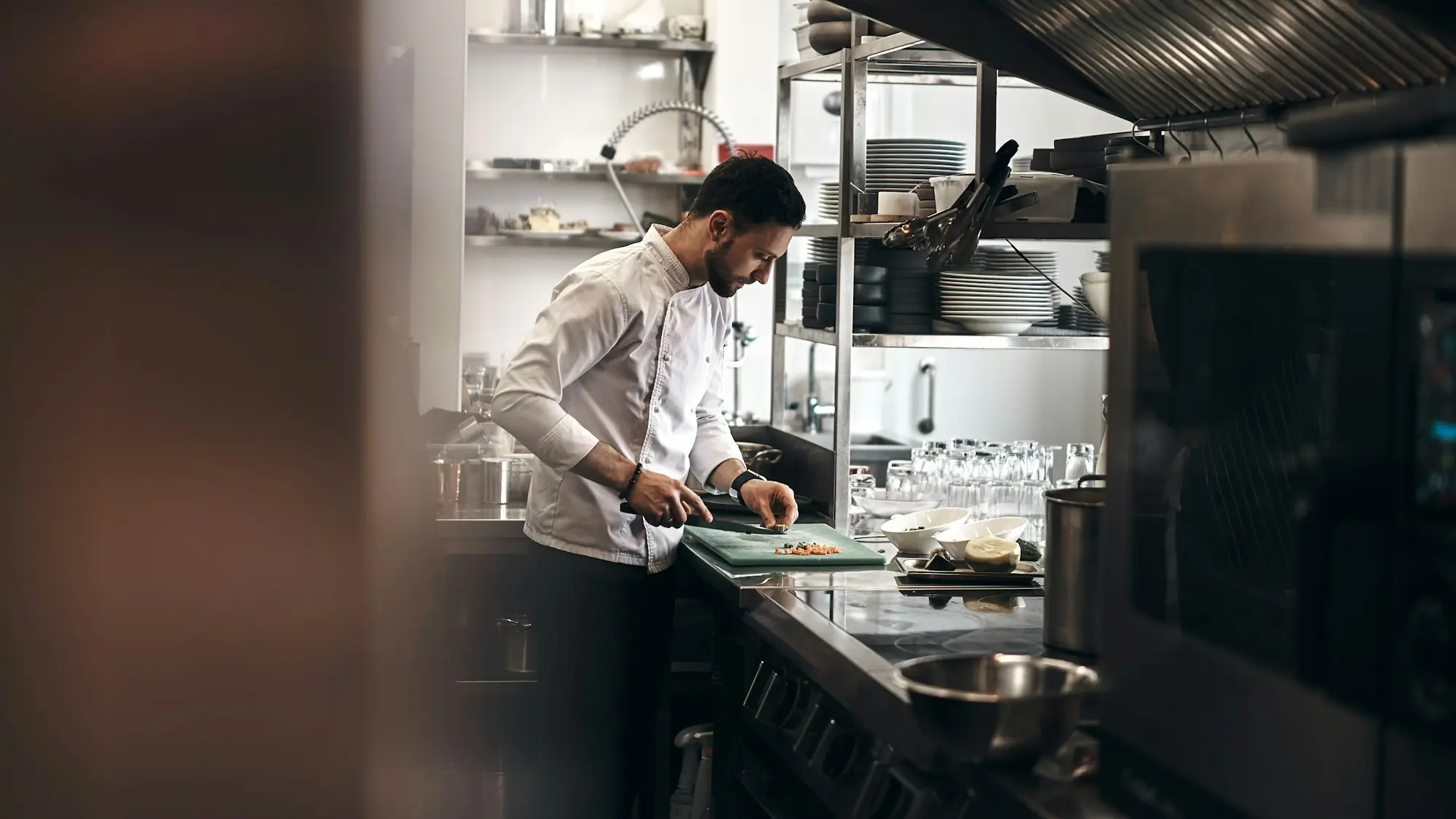 Chef and kitchen staff plating meals in a busy Rotorua restaurant kitchen