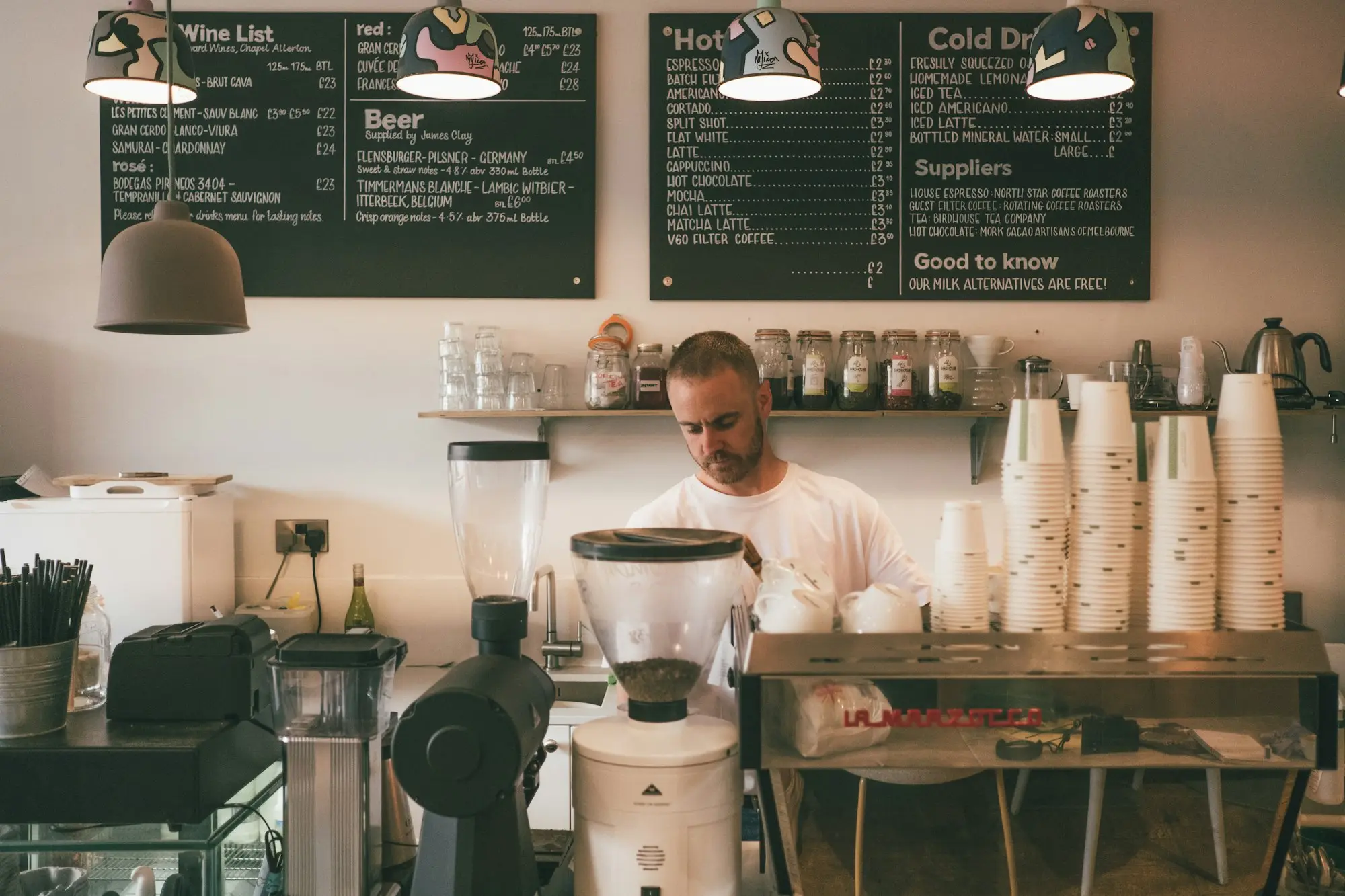 Cafe owner preparing coffee behind the counter of a small Wellington cafe on Cuba Street
